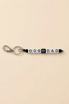 Porte-clef Dog Dad en perles acryliques blanches lettres noires et mauvais œil sur anneau argenté
