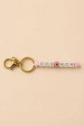 Porte-clef Dog Mom en perles acryliques blanches lettres dorées et cœurs roses sur anneau doré