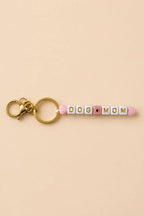 Porte-clef Dog Mom en perles acryliques blanches lettres dorées et cœurs roses sur anneau doré